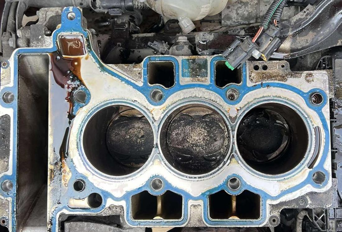 Engine block before work, covered in oil and carbon